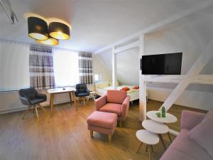 a living room with a couch and chairs and a tv at Zur Eiche in Ahlbeck