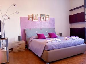 a bedroom with a purple bed with towels on it at Brà Guest House in Verona