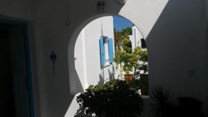 un arco en un edificio blanco con ventana en Antonia Studios, en Naousa