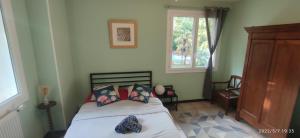 1 dormitorio con cama y ventana en B&B En plein coeur de la forêt, en Artiguelouve