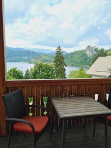 una mesa y sillas en un porche con vistas al lago en Vila Gorenka, en Bled