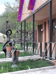 a building with a statue of birds in a yard at Hotel Skazka in Ijevan