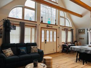 a living room with a couch and a table at Nature Escape Resort With Large Private Deck, Hot Tub, BBQ Grills, at Arrowhead Lake with 3 Pools, 4 Beaches at the Lakes and MORE in Thornhurst