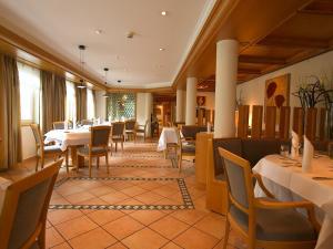 a restaurant with tables and chairs in a room at Hotel Am Park in Leinfelden-Echterdingen