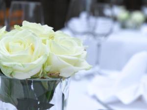 ラインフェルデン・エヒターディンゲンにあるHotel Am Parkのテーブルの上に白いバラが詰まった花瓶