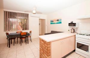 eine Küche und ein Esszimmer mit einem Tisch, einer Küche und einem Esszimmer in der Unterkunft Carnarvon Central Apartments in Carnarvon