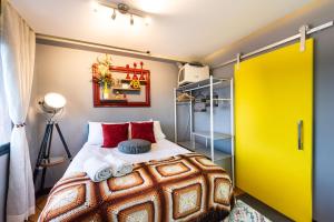 ein Schlafzimmer mit einem Bett und einer gelben Tür in der Unterkunft Apartamento Inteiro, Completo e Confortável in São Paulo