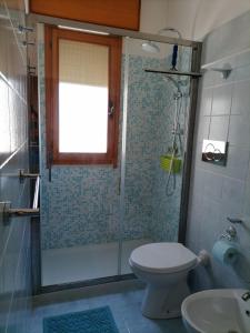 a bathroom with a shower and a toilet and a sink at Bilocale Kenya in Caorle +8 photos