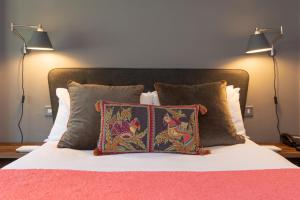 a bed with two lamps and two pillows on it at Jersey Arms Hotel Bicester in Bicester