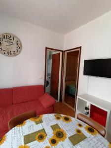 a living room with a red couch and a table at Bilocale Kenya in Caorle
