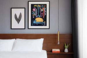 a bedroom with two framed pictures above a bed at MARQUEE Playa Hotel in Playa del Carmen