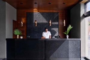 a man sitting at a counter in a room at MARQUEE Playa Hotel in Playa del Carmen