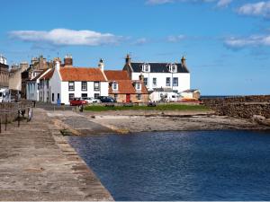 a town with houses and a body of water at Quaint, cosy bolt hole in Cellardyke in Cellardyke