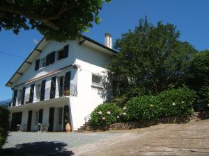 Una casa blanca con un árbol delante. en Villa Gypsie, en Urrugne