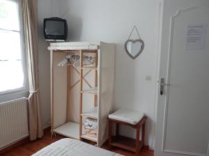 sypialnia z łóżkiem i telewizorem na półce w obiekcie Villa Gypsie w mieście Urrugne