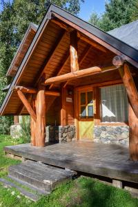 una baita di tronchi con portico e terrazza. di Cabaña para 4 pax ACCESO BAYO a Villa La Angostura