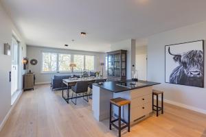 een open keuken en een woonkamer met een eetkamer bij BLACK PEARL Penthouse Black Pearl in Scharbeutz