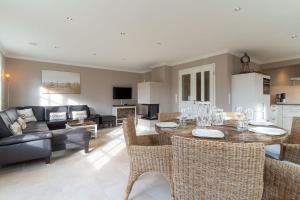 un salon avec une table, des chaises et un canapé dans l'établissement Reetdachhaus Dreilanden Reetdachhaus Sünn Hart, à Sankt Peter-Ording