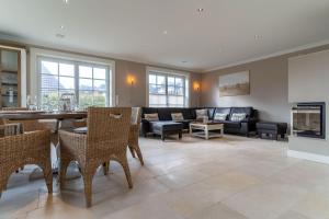 un salon avec un canapé et une table dans l'établissement Reetdachhaus Dreilanden Reetdachhaus Sünn Hart, à Sankt Peter-Ording