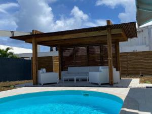 eine Pergola und ein Pool im Hinterhof in der Unterkunft Villa Nomilou Beach avec Accès direct Plage in Saint-François + 52 Fotos