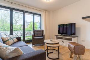 een woonkamer met een bank en een tv bij Appartement Kattrepel Appartement Kattstern in Sankt Peter-Ording