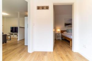 een woonkamer met een bed en een houten vloer bij Appartement Kattrepel Appartement Kattstern in Sankt Peter-Ording
