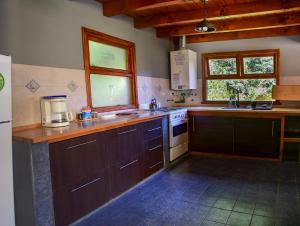 Una cocina con gabinetes de madera y encimera. en Cabaña para 4 pax ACCESO BAYO, en Villa La Angostura