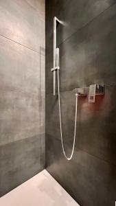 a shower with a hose in a bathroom at H-85 SUITES - BRIGHT Collection in Koblenz +65 photos