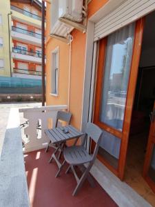 a patio with two chairs and a table and a window at Bilocale Kenya in Caorle