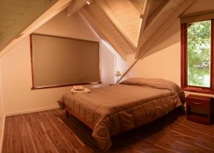 a bedroom with a large bed and a large screen at Cabaña para 4 pax ACCESO BAYO in Villa La Angostura