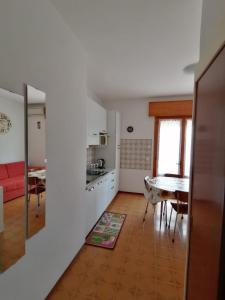 a kitchen and a living room with a table at Bilocale Kenya in Caorle