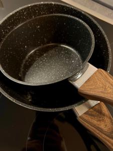 a person holding a frying pan with a spatula at H-85 SUITES LEVEL 2/4 in Koblenz