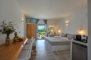 莫罗斯帕罗Anemones Studios & Suites - Onar Hotels Collection的一间卧室配有一张床和一张桌子及一碗水果