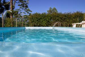 a large swimming pool with blue water at Pousada Vitoria in Gonçalves
