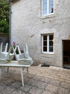 three white chairs sitting in front of a building at Gîtes « le clos saint Hilaire » in Mer