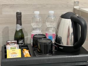 - Cafetera en bandeja con botellas de vino en Hostal Rías Bajas, en Madrid