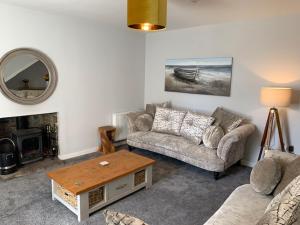 a living room with a couch and a table at Victoria Cottage, 8 Victoria Road in Orkney