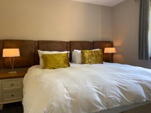 a bedroom with a large white bed with two lamps at Victoria Cottage, 8 Victoria Road in Orkney