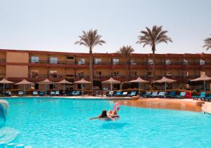 Retal View Resort El Sokhna Aqua Park في العين السخنة: وجود امرأة تسبح في المسبح في الفندق
