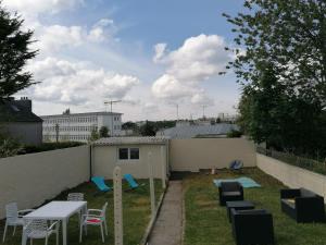 a backyard with a table and chairs and a fence at Studio Cosy - Parking - Wifi - Buanderie - Jardin in Brest