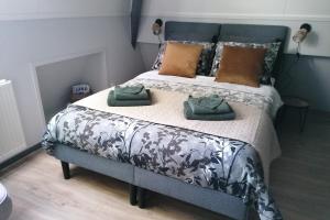 een slaapkamer met een bed met 2 kussens erop bij Tusken Wad en Wâld in Kollumerzwaag
