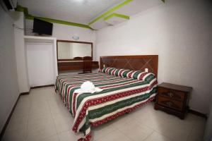 1 dormitorio con 2 camas, mesa y espejo en Hotel Nicte-Ha, en Campeche