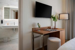 a room with a desk with a tv on the wall at Doria Park Hotel in Lerici +37 photos