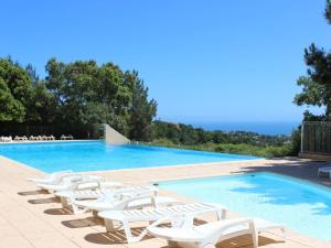 a swimming pool with white lounge chairs next to it at Appartement 6 couchages avec piscine et parking aux Issambres - FR-1-226-386 in Les Issambres