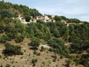 a village on top of a hill with trees at Appartement 6 couchages avec piscine et parking aux Issambres - FR-1-226-386 in Les Issambres