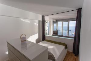 a bedroom with a bed and a desk with a window at Cullera Panoramic Sea Views Apartment in Cullera