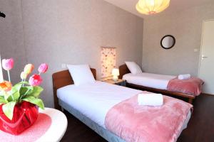 pokój hotelowy z dwoma łóżkami i wazonem z kwiatami w obiekcie HOLAVRE w mieście Arradon