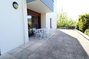 a patio with a table and chairs on the side of a building at HOLAVRE in Arradon