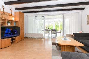 a living room with a couch and a tv at Haus Nordseepferdchen in Bensersiel