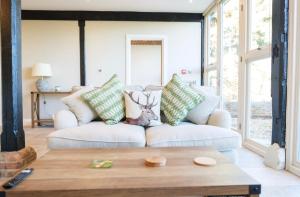a living room with a white couch with pillows at Greentrees Estate - Pine Cottage in Balcombe